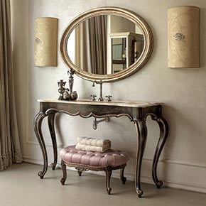 _Mobile bagno Lester in legno, finitura ebano, cat. B con particolari in foglia argento rosato, cat. C, lavabo sottopiano e top in marmo
calacatta oro, rubinetteria modello retrò trefori in cromo</br>
_Specchiera Orlando in legno, finitura foglia argento rosato, cat. C</br>
_Applique alì in tessuto fiore con swarovski beige, cat. E</br>
_Pouff nouvelle in legno, con rivestimento capitonnè in tessuto, cat. C, con struttura in finitura prugna laccato lucido, cat. A