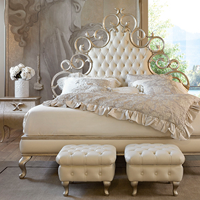 _Medea Carved wood bed
                 dove grey silver leaf finish, cat. C,
                button-tufted headboard and bed surround 
                 in ivory leather.
                <br>
                _Medea nightstand
                 in dove grey silver leaf finish, cat. C. 
                <br>
                _Regina square pouff
                 ivory leather.
                <br>
                _Liberty 4-door wardrobe
                 in wood, dove grey silver leaf finish, cat. C, 
                 with Amore e Psiche decoration.
                