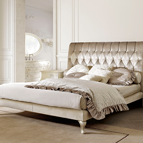 _Letto imbottito Miss
    Capitonne in tessuto.
    <br>
    _Comodino Oliver
     in finitura foglia argento champagne, 
     cat. c con decoro fiori.