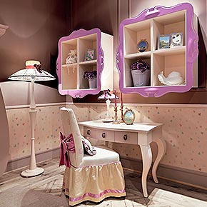 _Scrivania Rio in legno in finitura avorio caldo, cat. A, frontali cassetto in finitura mousse cake, cat. B, con maniglie silhouette, finitura prugna opaco</br>
_Sedia Castellana in legno, con rivestimento in tessuto luce con ricamo silhouette, cat. B, fiocco posteriore, profili e nastro in tessuto Luce/34, cat. B, balza inferiore in tessuto luce liscio, cat. B</br>
_Libreria Camille con struttura interna in legno finitura avorio caldo, cat. A e cornice di metallo in finitura fuxia laccato lucido, cat. A