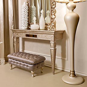 _Consolle epoque in finitura foglia argento tortora, cat. C con top in specchio bronzo e decoro windsor </br>
_Specchiera Pitti in legno, finitura foglia argento tortora, cat. C</br>
_Lampada da terra operà in legno, finitura cameo, cat. B con paralume in tessuto, cat. B e marabù</br>
_Pouff nouvelle in legno capitonnè, rivestimento in tessuto Luce, cat. B e piedi in finitura cameo, cat. B
