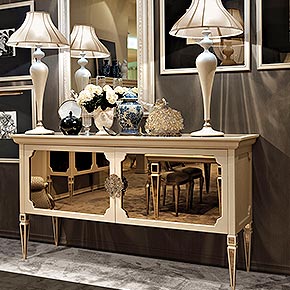 _Credenza Epoque in legno, finitura Cameo, cat.B, 
gambe con inserti a specchio bronzo, ante e top in specchio bronzo, maniglie Epoque in metallo, finitura foglia argento tortora</br>
_Lampada da tavolo Operà in legno, finitura Cameo con particolari foglia argento </br>
tortora cat.B, paralume in tessuto Ponge/17, cat.A</br>
_Specchiera Windsor in legno, finitura Cameo cat.B, specchio naturale