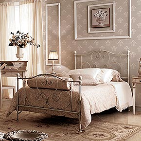 _Letto in ferro forgiato a mano finitura avorio ceramizzato, cat. B</br>
_Parure lenzuola Sogno</br>
_Comodini Tamburo in legno, finitura Nettuno avorio, cat. D</br>
_Abatjour Rina in legno, finitura foglia argento décapé, cat. C, con paralume Plissé in tessuto Aurora/04, cat. B</br>
_Lampada da terra Torciera in legno, finitura foglia argento décapé, cat. C, con paralume Plissé in tessuto Aurora/04, cat. B